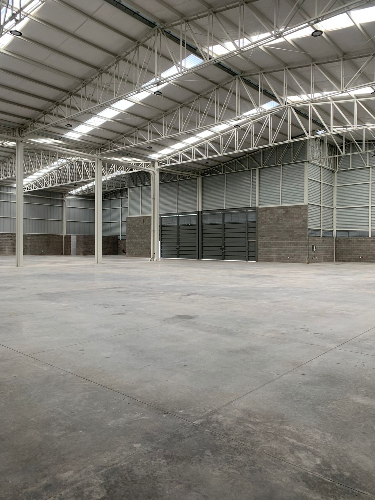 Interior de nave Delta con columnas metálicas y piso industrial, constructora Fer Et Ciment León Guanajuato