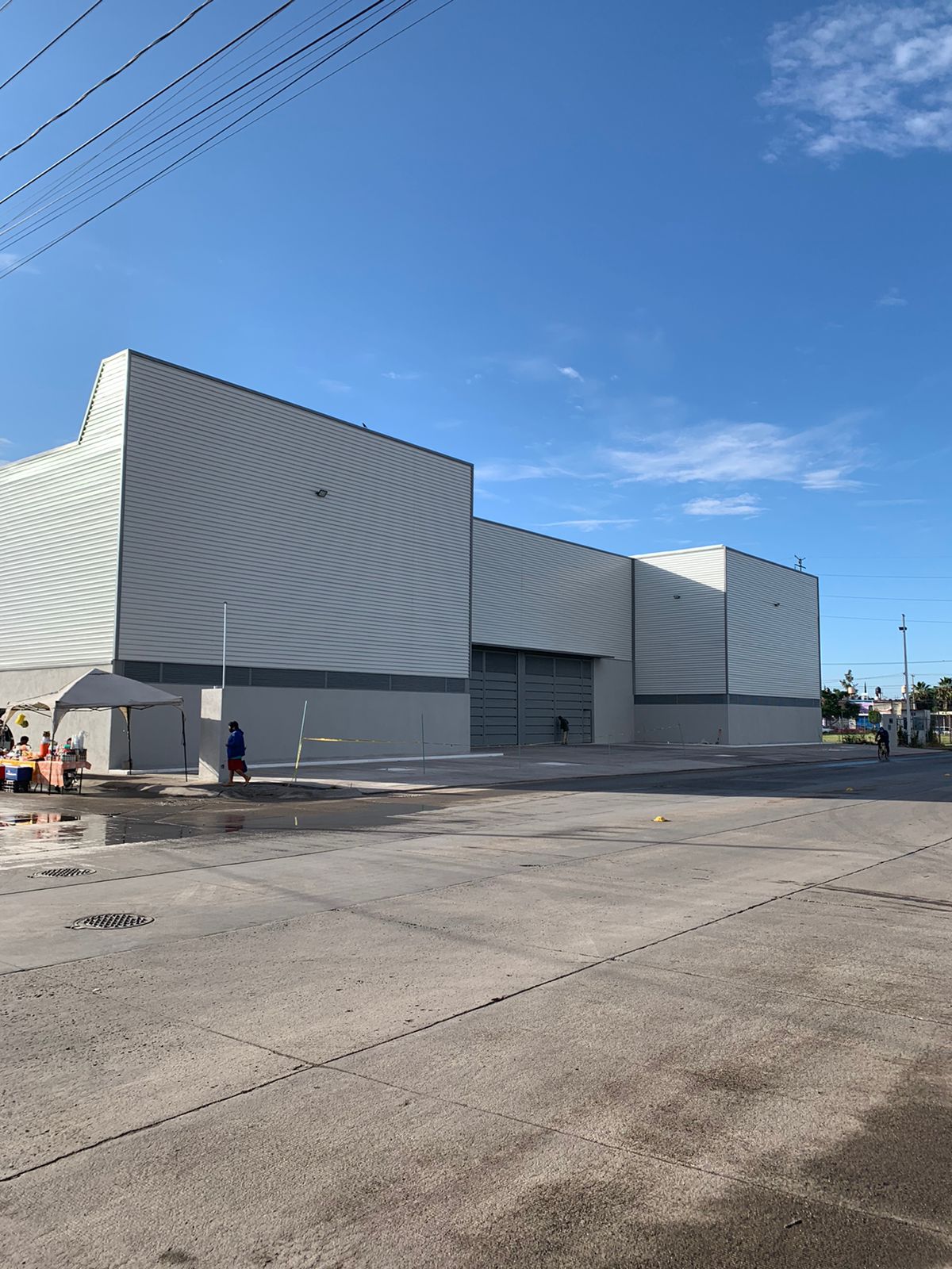 Fachada exterior de nave industrial Delta terminada con acceso de carga y patio de maniobras, Fer Et Ciment León