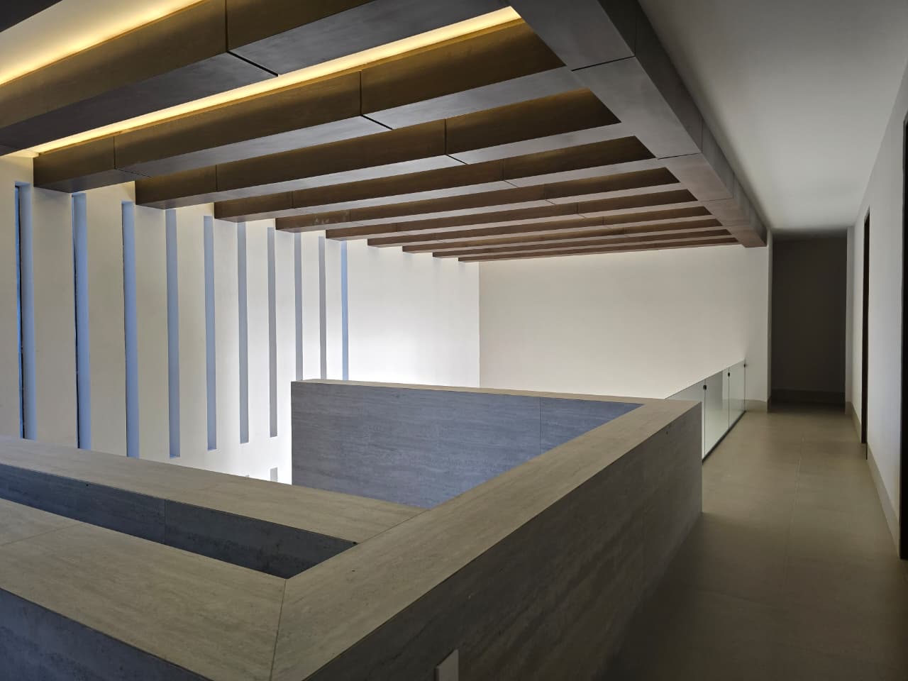 Cocina de diseño contemporáneo con isla central, iluminación colgante y acabados en madera, residencia Misión Cañada Fer Et Ciment