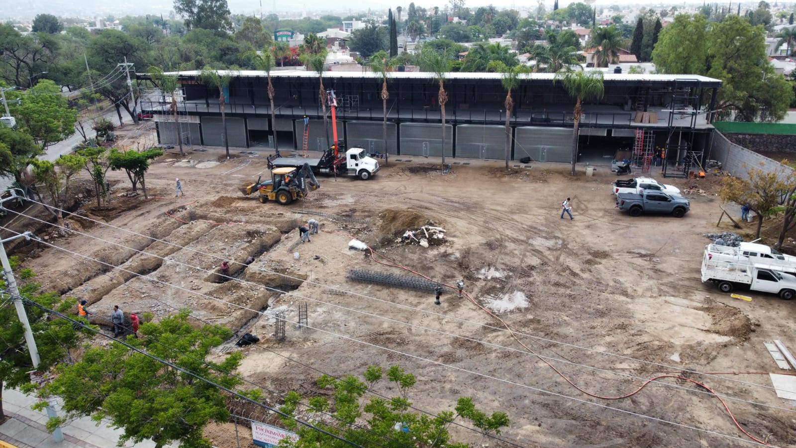 Etapa de acabados exteriores de Plaza Magnolia con fachada y área de estacionamiento, Fer Et Ciment León